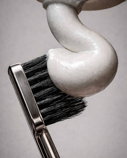 Toothbrush with toothpaste on a gray background