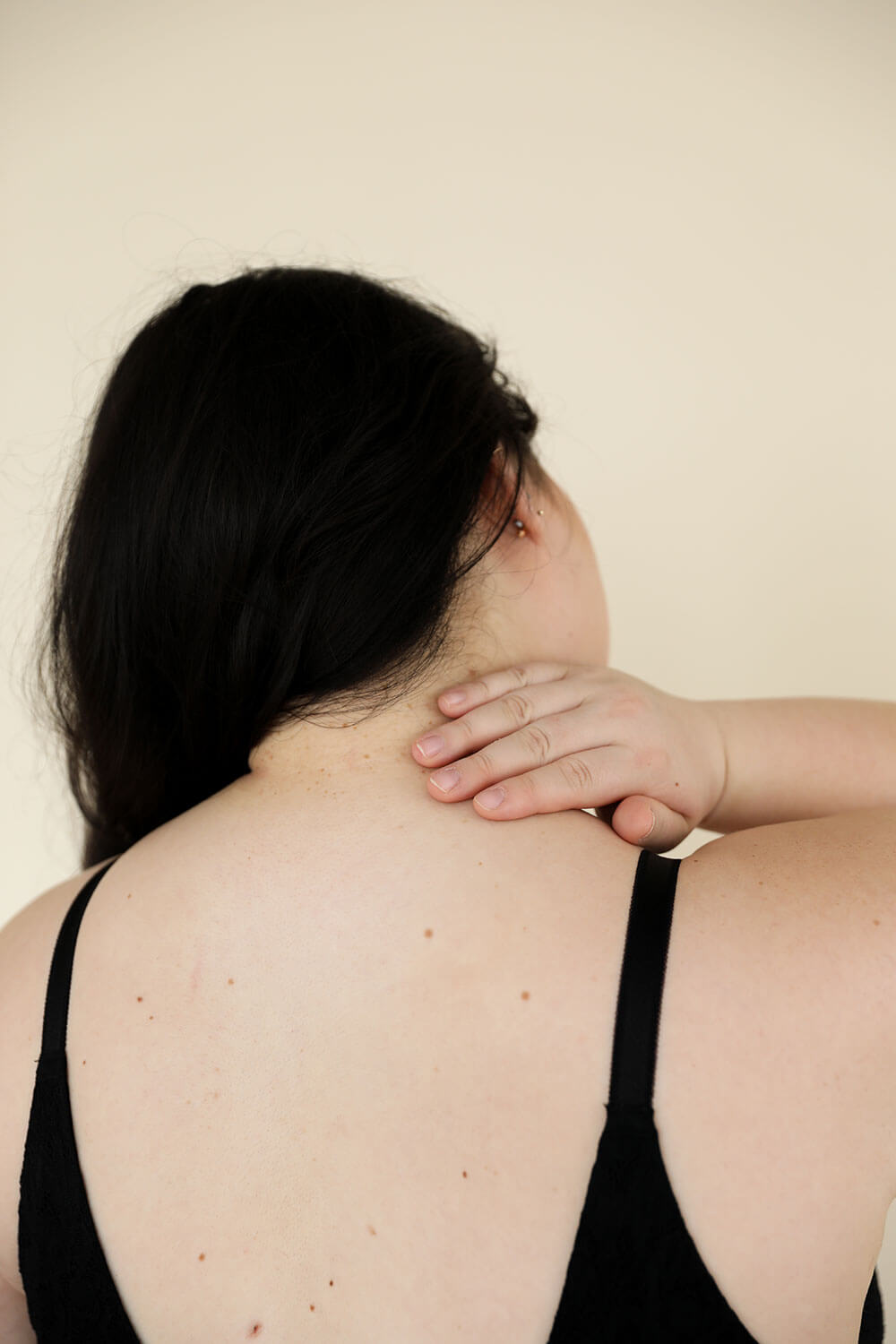 woman rubbing back of shoulder