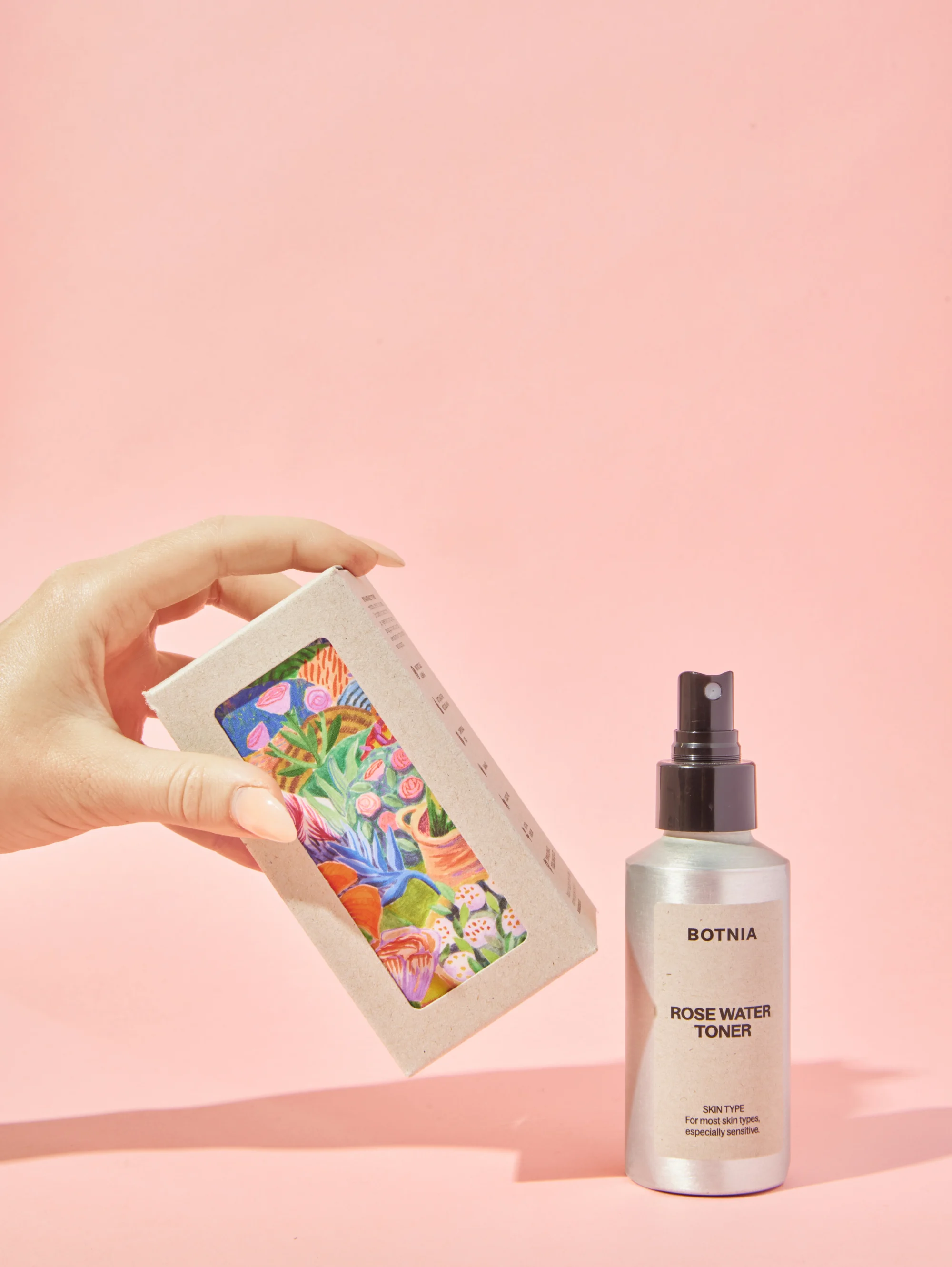 A bottle of Rose Water Toner from the brand Botnia on a light pink background